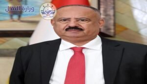 وزير النقل اليمني محسن حيدرة العمري مع علم الجمهورية اليمنية